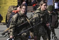 ukrainian soldiers with rifles walking down the street