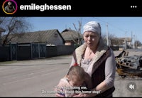 a woman is holding a child in front of a street