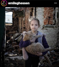 a young girl holding a cat in an abandoned building
